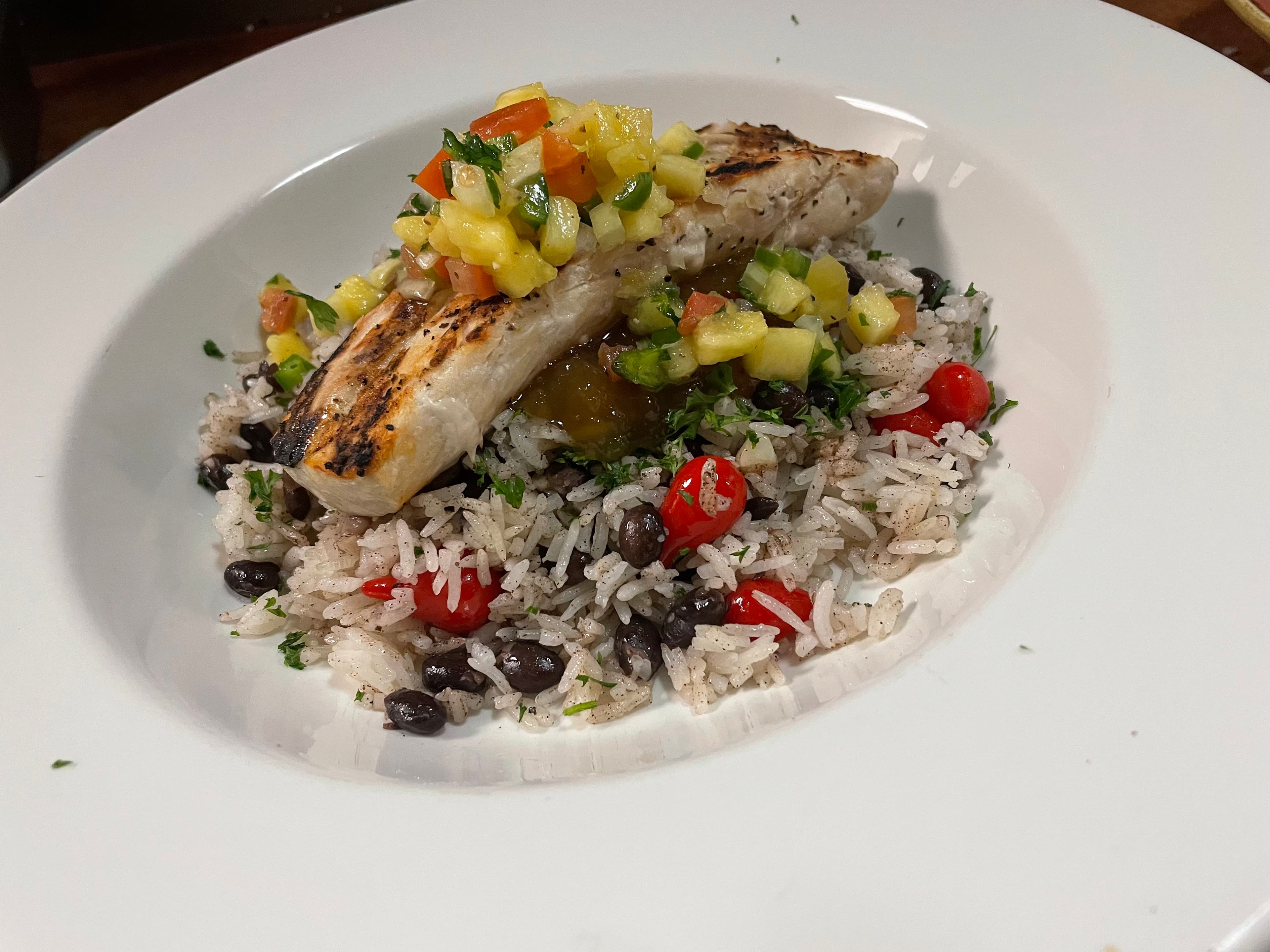 Grilled fish over black bean rice with tropical pineapple salsa