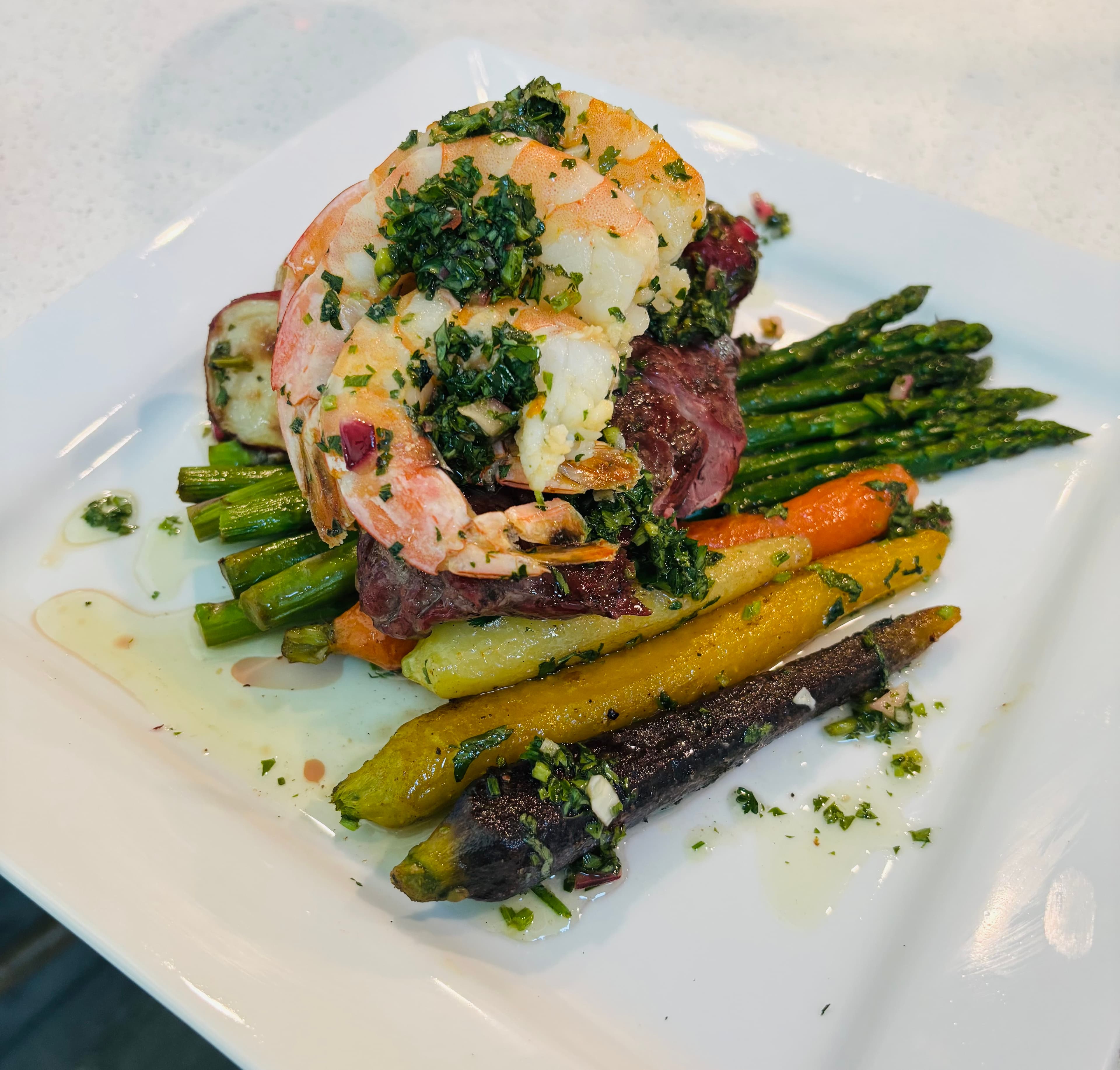 Surf and turf plate with shrimp, steak, and roasted vegetables